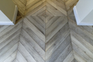 In the entry, gray chevron floor parquet (45) is reversed in the middle of the room